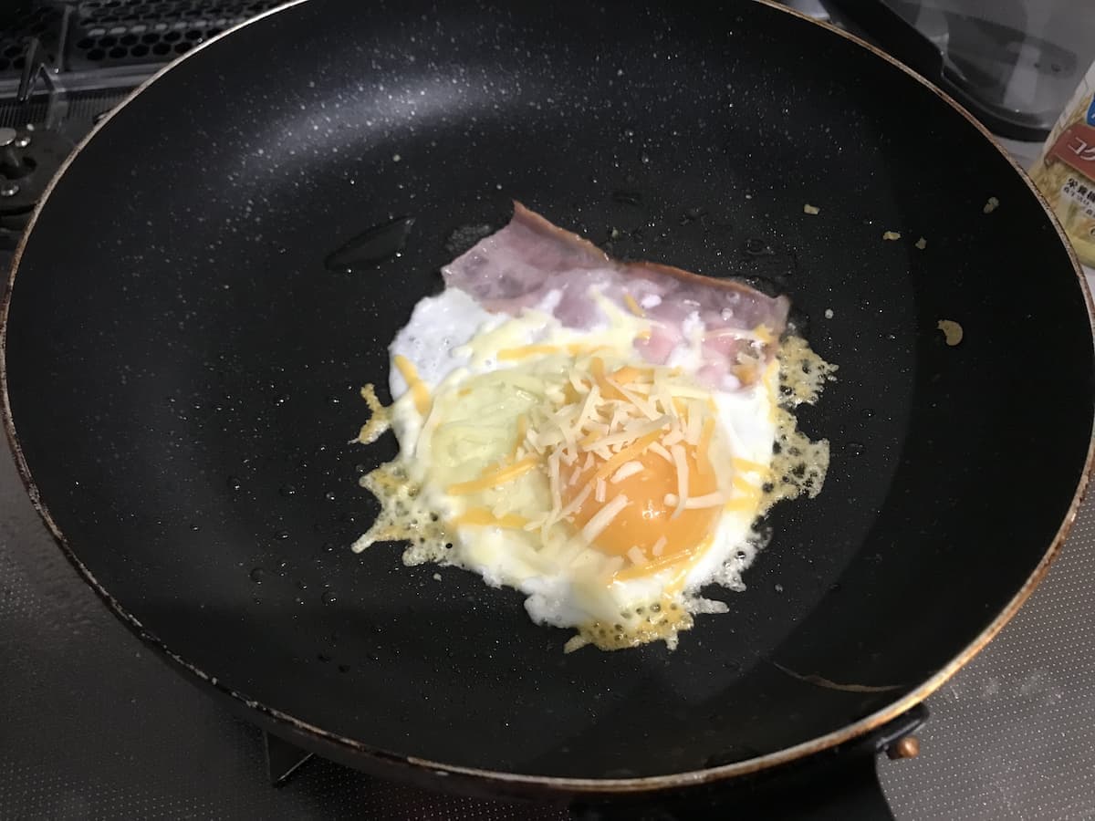 チーズベーコンエッグ　チーズをのせた写真