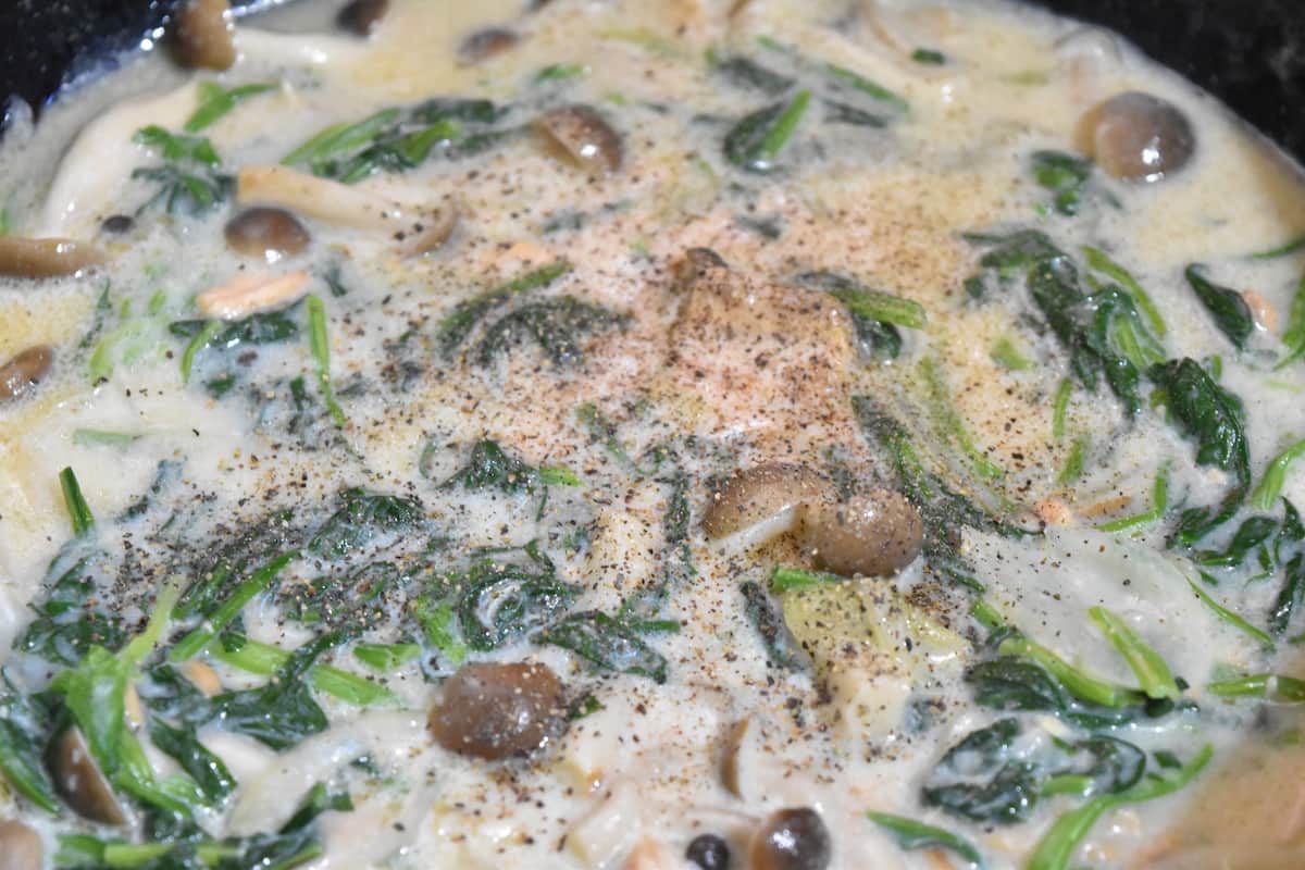 ほうれん草を加えあらびき黒コショウをふる(鮭缶とほうれん草の豆乳クリーム煮)