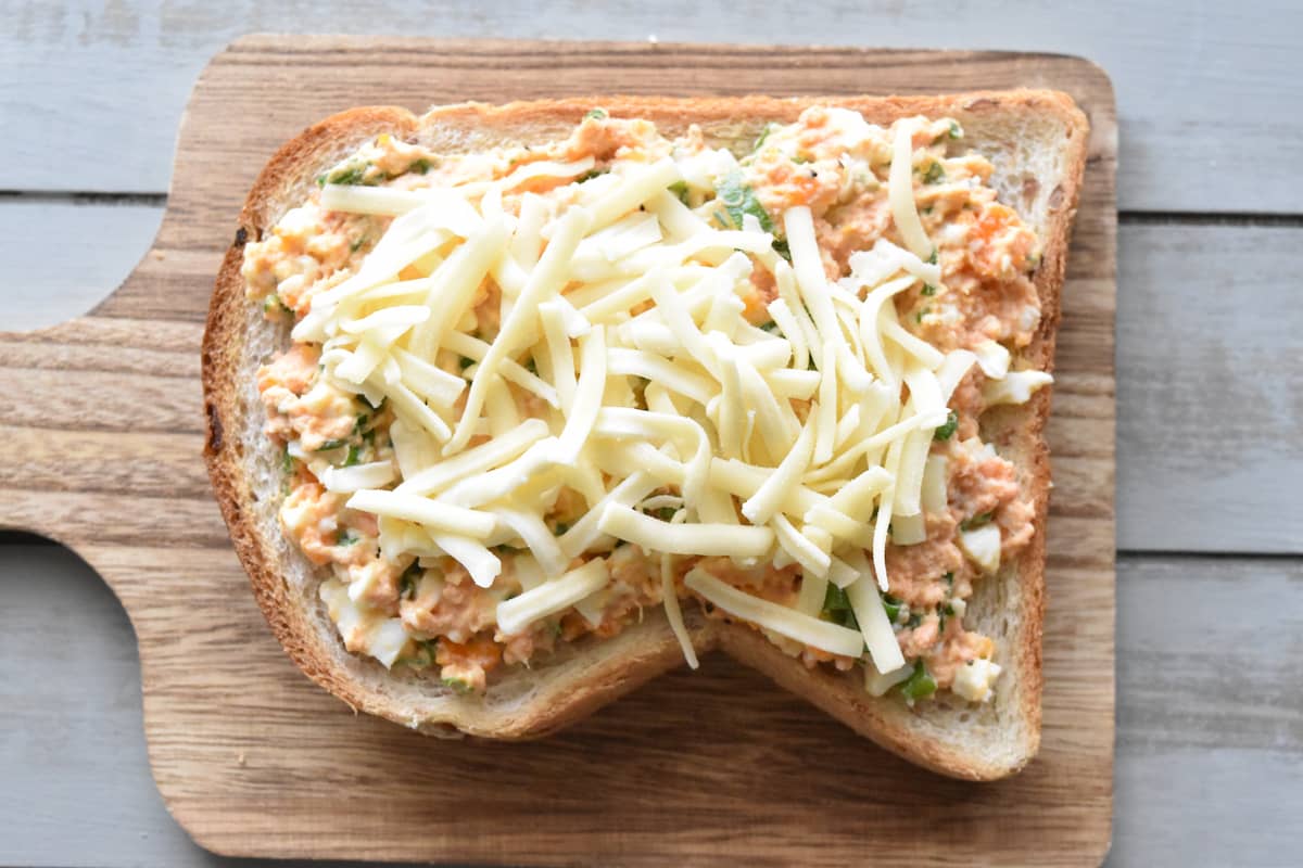 食パンの上に具とピザ用チーズをのせてトーストする(鮭フレークのトースト)