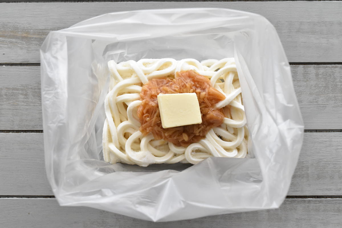 ポリ袋に冷凍うどん、バター、なめ茸をのせる(ポリ袋でなめ茸バターうどん)