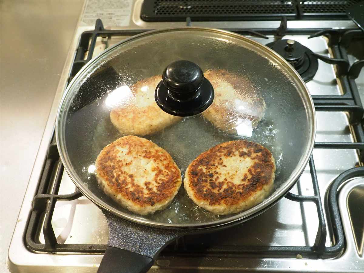 こんにちは、筋肉料理人です。今日は鶏ひき肉と豆腐を使った塩ハンバーグレシピを紹介させて頂きます。鶏ひき肉と豆腐を使うので合いびき肉より材料代が安く、ボリュームたっぷりに作っても豆腐なので低カロリー。お腹いっぱいになっても、食後感が軽いのがいいところです。そしてもちろんですが味も妥協無し、豆腐をたっぷり使いますが、いかにもハンバーグって味に仕上げます。

豆腐ハンバーグを美味しく作るコツですが、まずは豆腐の種類の選別です。豆腐にはソフト、絹、木綿、厚揚げ等幾つか種類があります。ソフト豆腐と絹豆腐は水分が多く、水切りしにくいので向いていません。木綿豆腐と厚揚げはどちらも水分量が少ないので向いていますが、厚揚げは油で揚げているので風味が強いです。ですので、今回は水分量が少なく、ハンバーグの風味に合う木綿豆腐を水切りして使いました。

そしてもう一つ、ハンバーグを美味しく作るコツなんですが、やっぱり炒め玉ねぎにつきると思います。玉ねぎを炒めてあめ色にし、玉ねぎの甘味をメイラード反応で旨味に変え、旨味と風味を入れる。これが大事でしょう。そして、今回は豆腐を使うので、その風味をどうするかです。豆腐の風味が何より好きって方はそのままでいいですが、ハンバーグ寄りが好きって方も多いでしょう。普通のハンバーグっぽい風味にする為、おろしにんにくを入れます。豆腐の風味は意外に強いので、にんにくの風味でマスクするわけです。


鶏ひき肉と豆腐の塩ハンバーグ

材料4人分
調理時間

鶏ひき肉　200g
木綿豆腐　1/2丁(200g)
玉ねぎ　1個(200g)
サラダ油　小さじ3
塩　適量

A
パン粉　大さじ6
マヨネーズ、片栗粉　各大さじ2
おろしにんにく　小さじ１/２
塩、鶏がらスープの素　各小さじ１/２
黒こしょう　小さじ1/３

作り方

１．木綿豆腐を大き目の皿にのせ、その上に皿をかぶせます。600mlのペットボトルに水を入れ、皿にのせて重しにして1時間、水切りします。
２．玉ねぎをみじん切りにし、サラダ油大さじ1/2を引いたフライパンに入れ、強めの中火で炒めます。5分程、焦げないように混ぜながら炒め、濃いめのあめ色になったら取り出して冷まします。※色づいてくると焦げやすくなるので、火加減を注意してください。炒めた後は金属製のバットに広げて入れると冷めやすいです。
３．ボウルに水切りした木綿豆腐を入れてつぶし、Aを入れて混ぜます。鶏ひき肉を加えて粘りが出るまで練ります。これを4等分し、小判型に形を整えて真ん中を凹まし、薄く小麦粉をまぶします。※Aのマヨネーズの効果でハンバーグがふっくら柔らかになります。タネを小判型に整えたら、クッキングシートの上に置くと、くっつかないので小麦粉をまぶしやすいです。小麦売をまぶして焼く事で、ジューシーさが増します。
４．フライパンにサラダ油大さじ1を引いて中火にかけ、3）のタネを入れて焼きます。2～3分焼いて焼き目がついたら返し、お湯1/4カップを入れてフタをし、5～6分、弱めの中火で蒸し焼きにします。蒸し焼きにしたらフタを外し、中火で焼いて水分を飛ばしたら出来上がりです。

皿に盛り付け、ブロッコリーとミニトマトを添え、皿の端に後付け用の塩を盛り付けます。

鶏ひき肉と豆腐の塩ハンバーグの完成です！
焼き目がついた見た目はハンバーグそのもの、表面はカリッとしていますが箸で切れる柔らかさです。塩ハンバーグなので最初はそのまま食べると焼き目の香ばしさを感じ、噛むと肉感と滑らかな食感があり、旨味のある塩味が口に広がります。肉の旨味と一緒に豆腐の風味がかすかに残る感じで、滑らかな食感で豆腐が入っているとわかる程度で、とても美味しいです。あと付けで塩をつけて食べると、はっきりした塩味が加わって味変し、ご飯、ビールがいける味になります。
豆腐が入っているので冷えても柔らかく、お弁当のおかずにもおすすめ。今回は主菜として作ったので、大きなハンバーグサイズにしていますが、タネを8等分、あるいは16等分にして焼き、それを冷凍して作り置き惣菜にするのもいいでしょう。鶏ひき肉と豆腐の塩ハンバーグをお試しください。